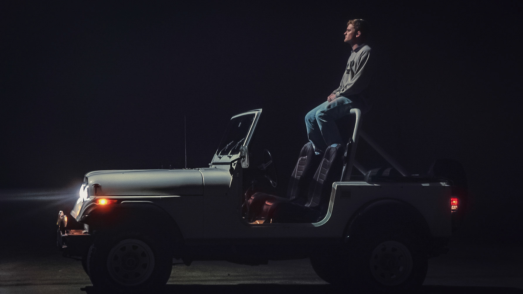 Atmospheric night portrait of person with utility vehicle using creative lighting