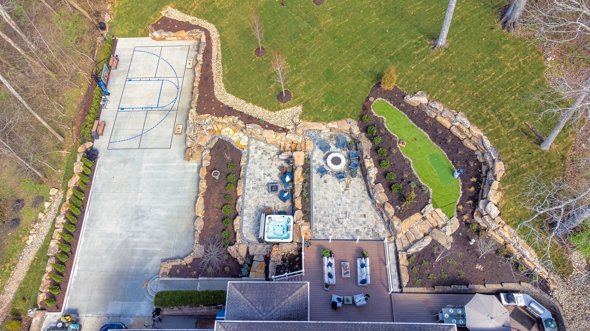 Comprehensive aerial view of luxury estate with basketball court and outdoor amenities