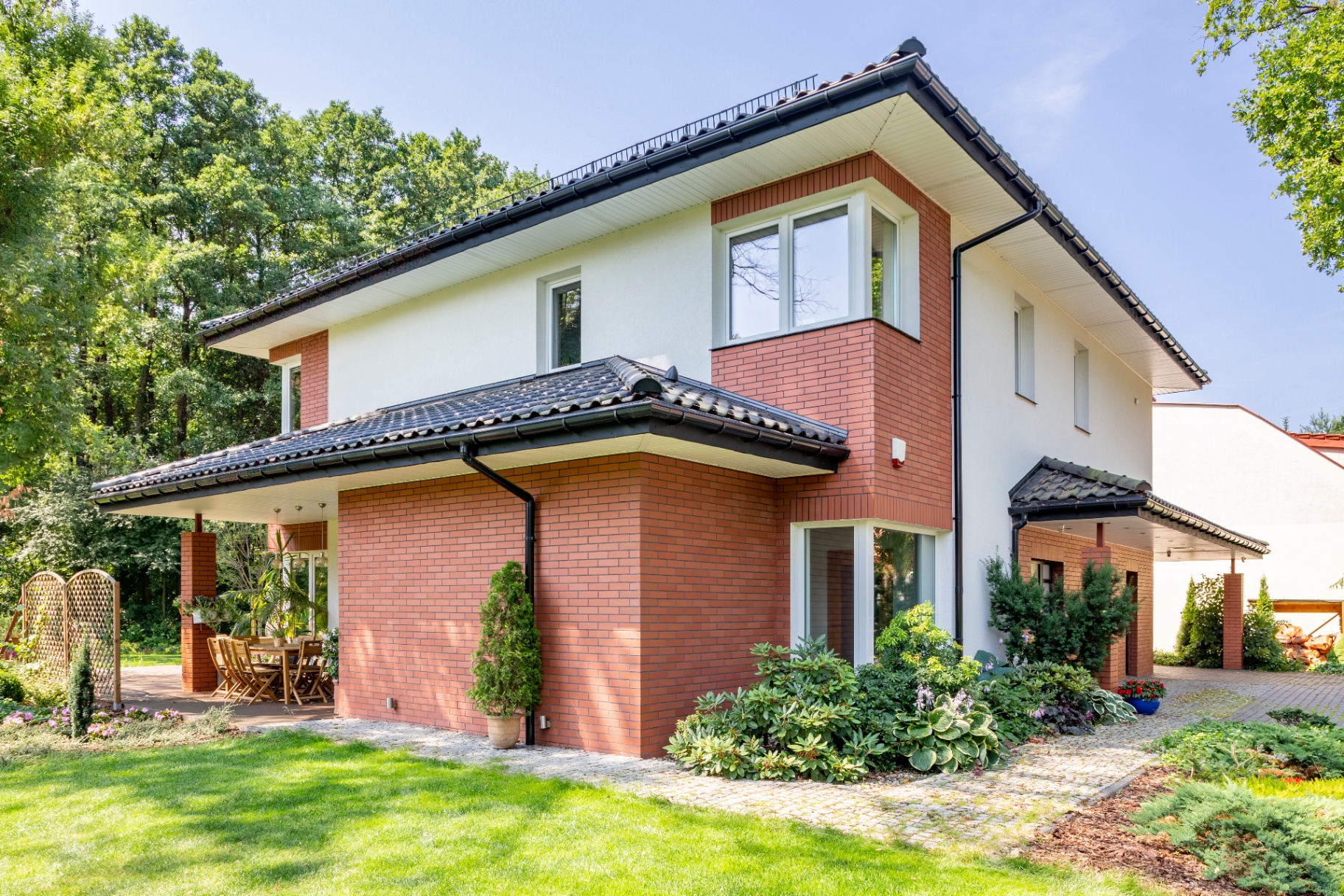 Beautiful modern brick home exterior with landscaped garden and patio