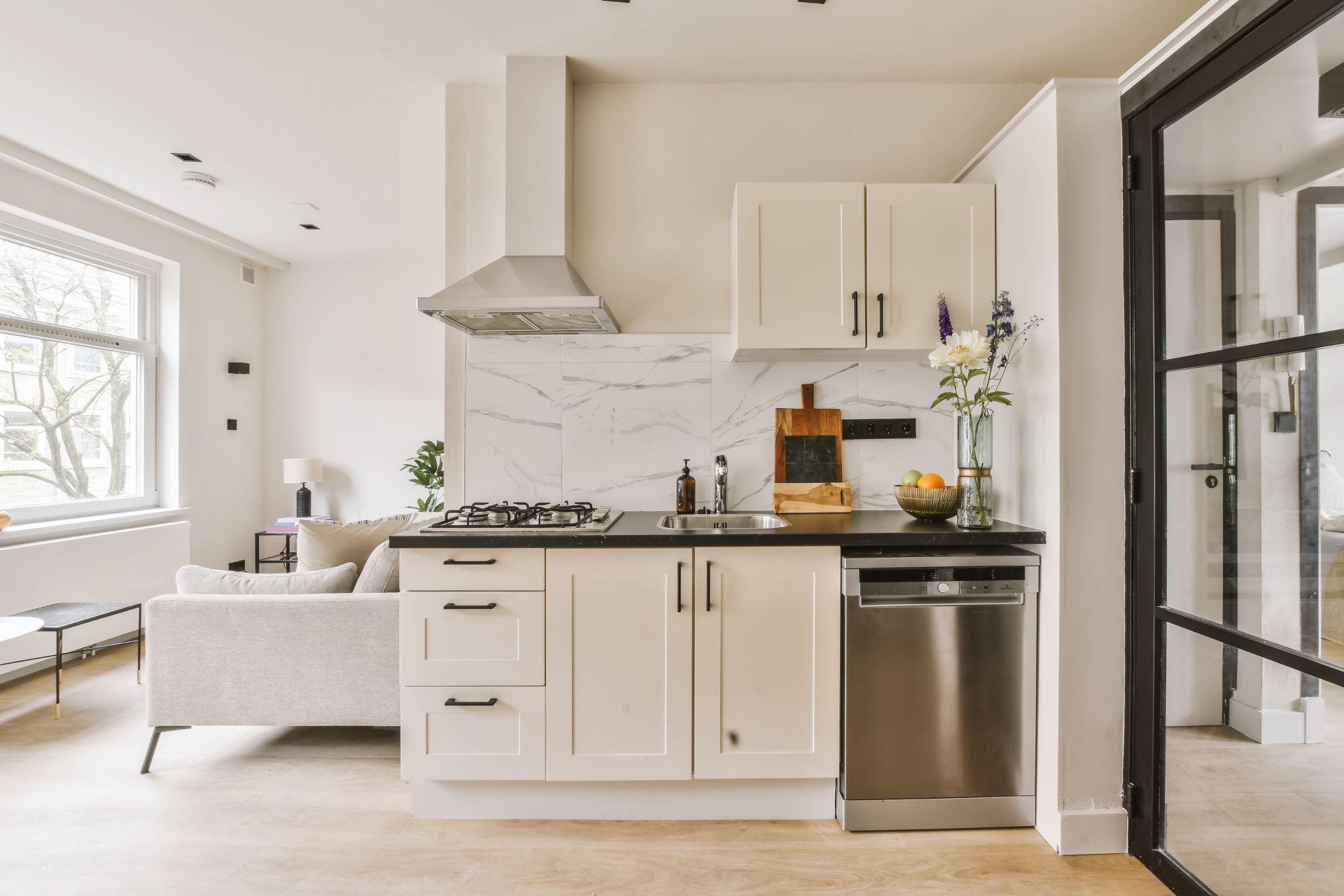 Sleek modern kitchen with white cabinets, marble backsplash and stainless steel appliances