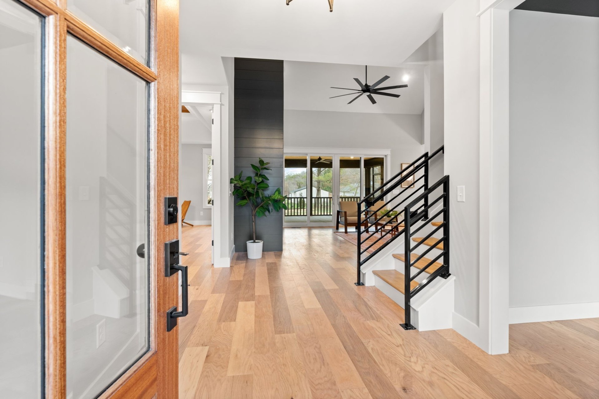 Impressive entryway featuring modern black railings, hardwood floors and open concept design