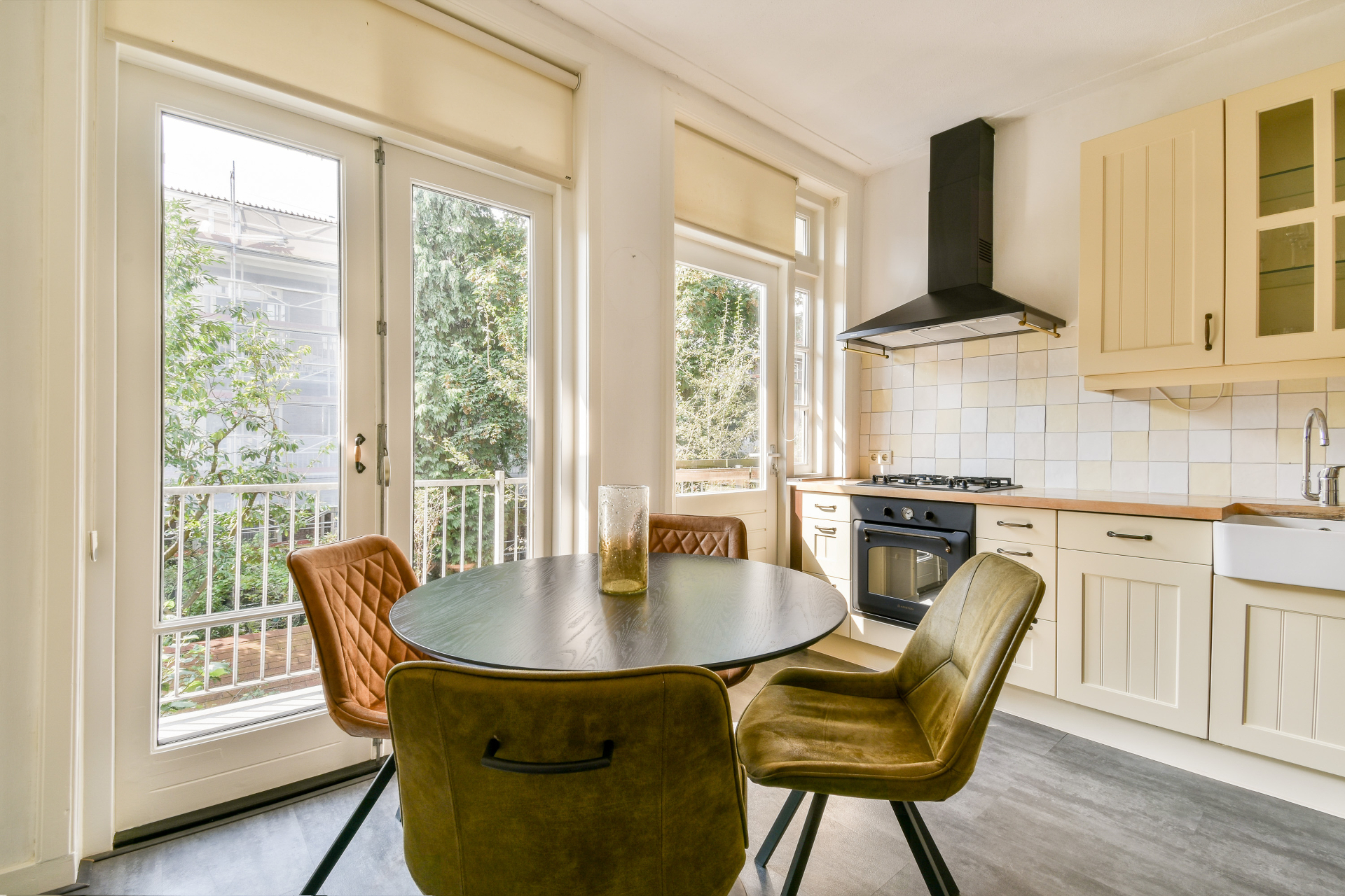 Beautiful kitchen with cream cabinets, round dining table and mustard velvet chairs