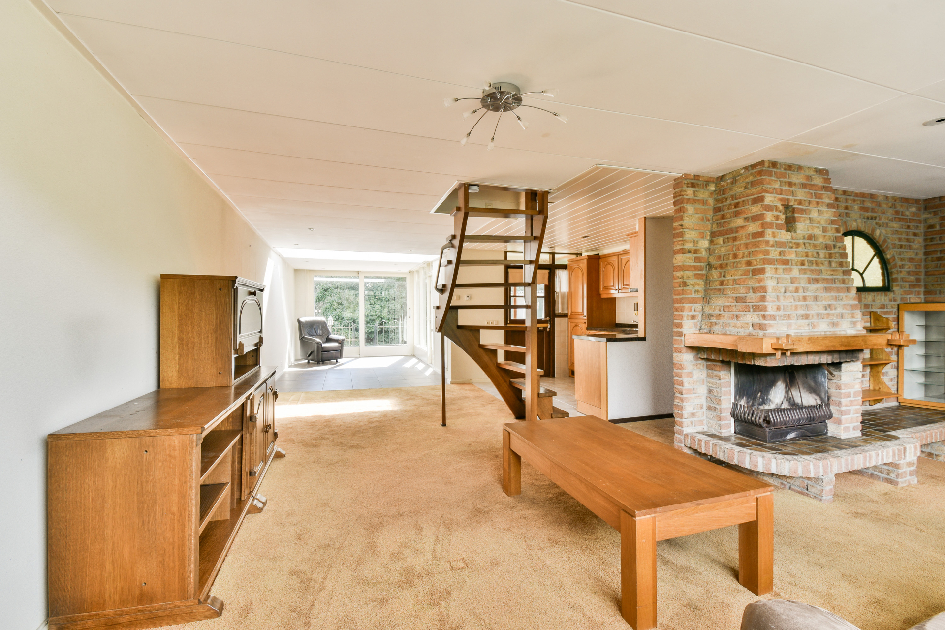 Warm living space featuring exposed brick fireplace and wooden architectural elements