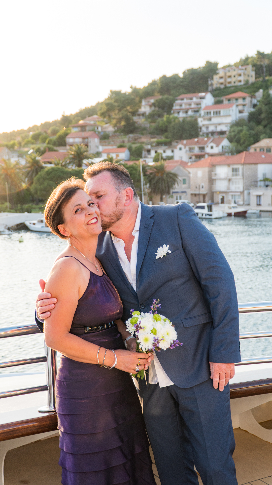Romantic couple portrait on boat with Croatian coastal town backdrop
